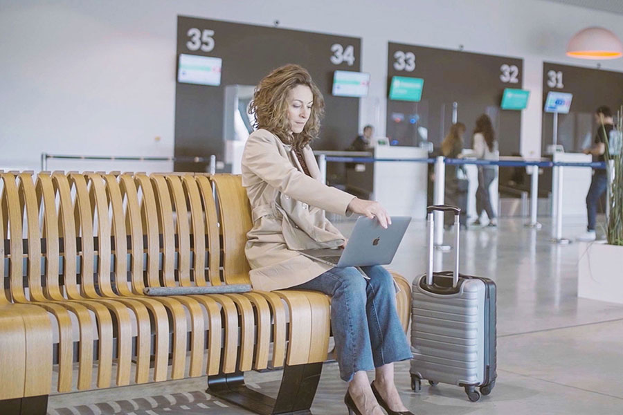 Femme qui utilise Mozaik connect dans un aéroport, vue large